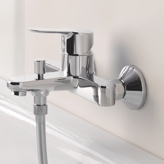 GROHE BauEdge single-lever bath mixer. A wall-mounted bath tap with automatic bath/shower diverter. Chrome finish, water-saving adjustable flow rate l